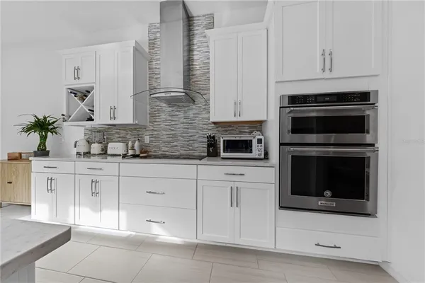a kitchen with white cabinets and appliances
