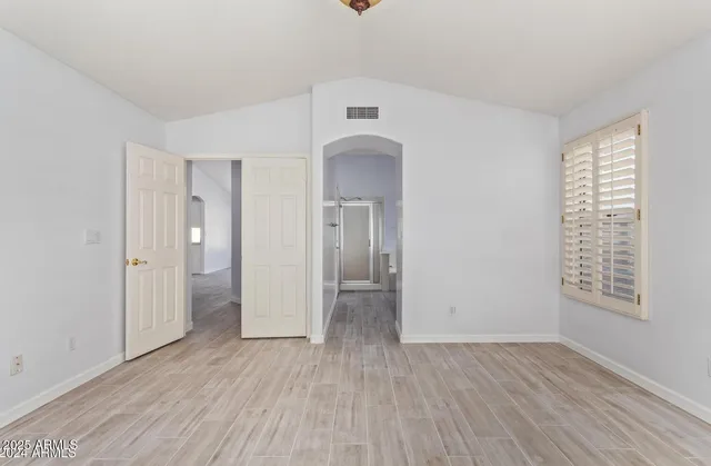 an empty room with windows and fan