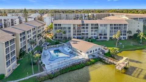 an aerial view of a house with a garden and lake view