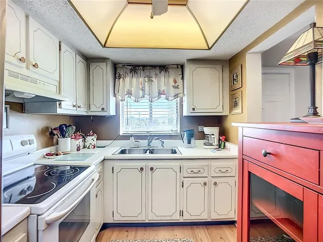 a kitchen with a sink cabinets and window