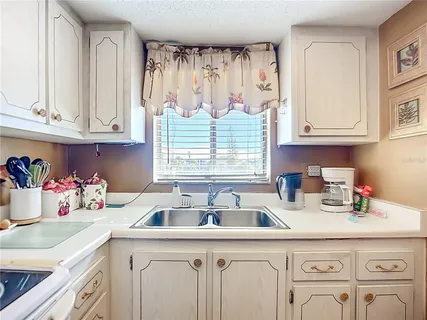 a kitchen with white cabinets a window and a sink