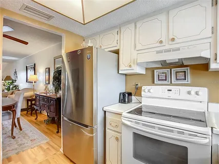 a kitchen with stainless steel appliances white cabinets and a refrigerator