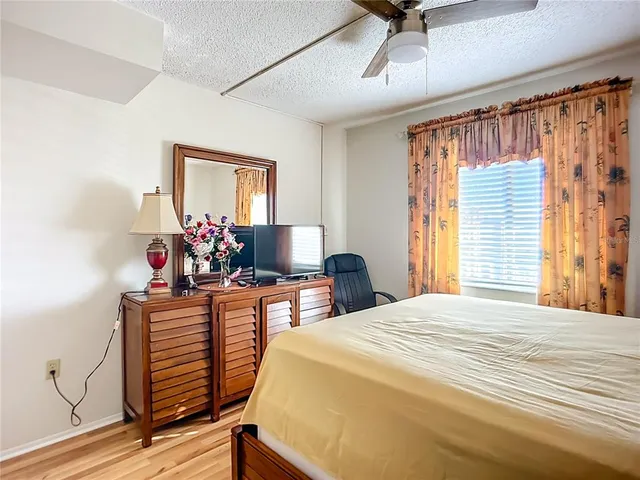 a bedroom with a bed table chair and a window
