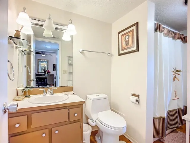 a bathroom with a granite countertop sink toilet a mirror and shower