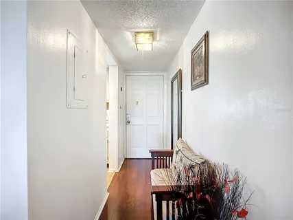 a view of a hallway with wooden floor and dining room