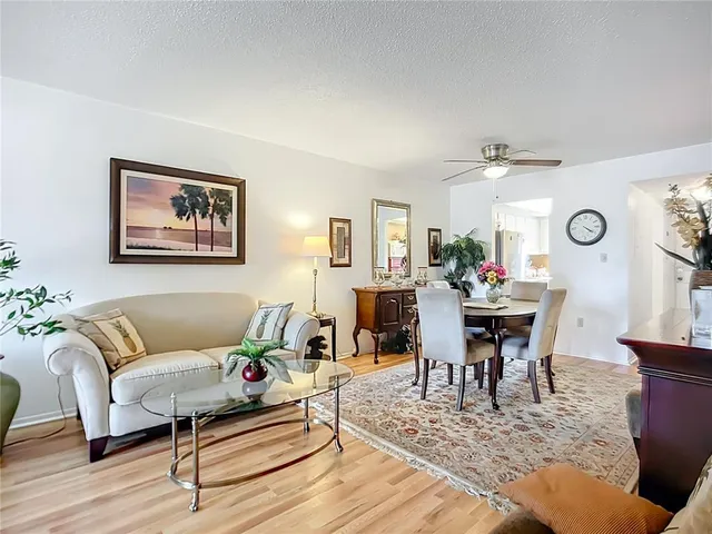 a living room with furniture and view of kitchen