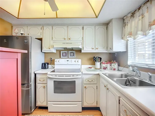 a kitchen with stainless steel appliances granite countertop a sink stove and cabinets