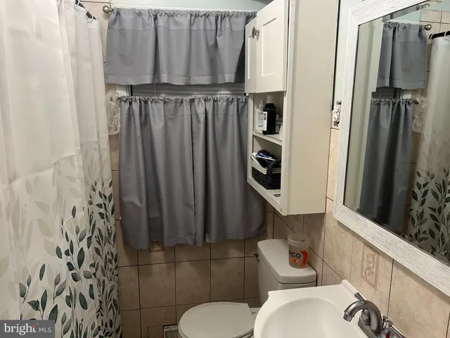 a bathroom with a toilet and a shower curtain
