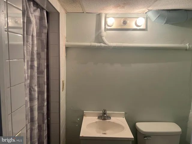 a bathroom with a toilet a sink and mirror