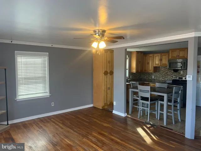 a view of a livingroom with furniture chandelier fan and windows