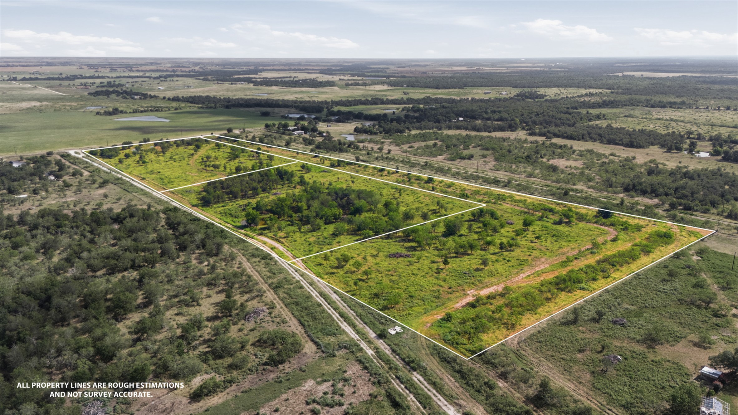 3280 County Road 466 Elgin, TX 78621 - Photo 2 of 13 An aerial perspective showcases a vast, green lot bordered by natural landscapes, ideal for development.