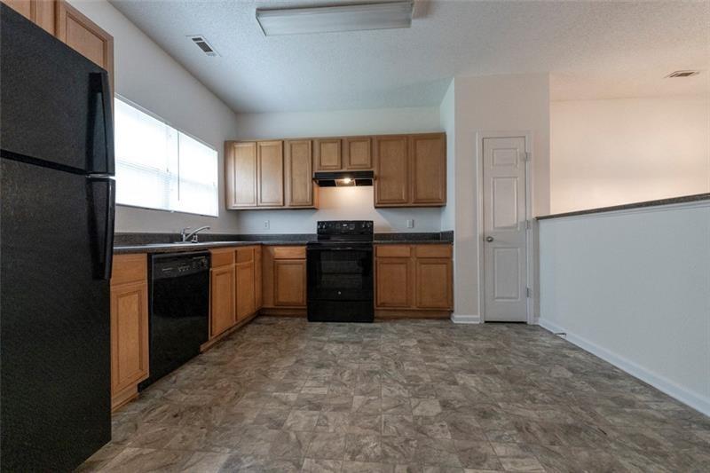 6045 Capitol Knoll Fairburn, GA 30213 - Photo 16 of 37 a kitchen with granite countertop a stove sink and cabinets