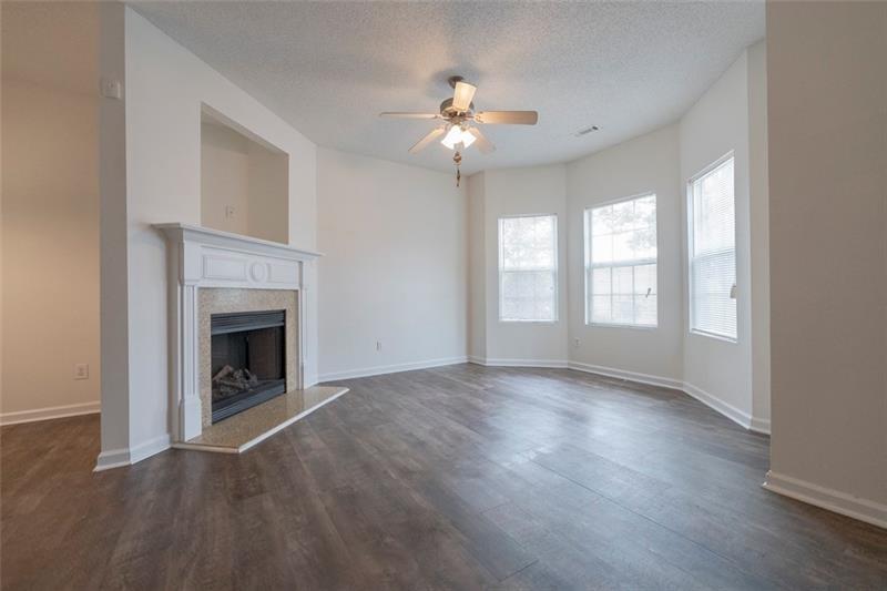 6045 Capitol Knoll Fairburn, GA 30213 - Photo 4 of 37 wooden floor fireplace and windows in an empty room