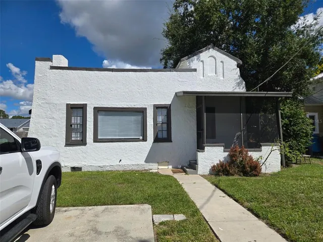 a front view of a house with a garden and yard