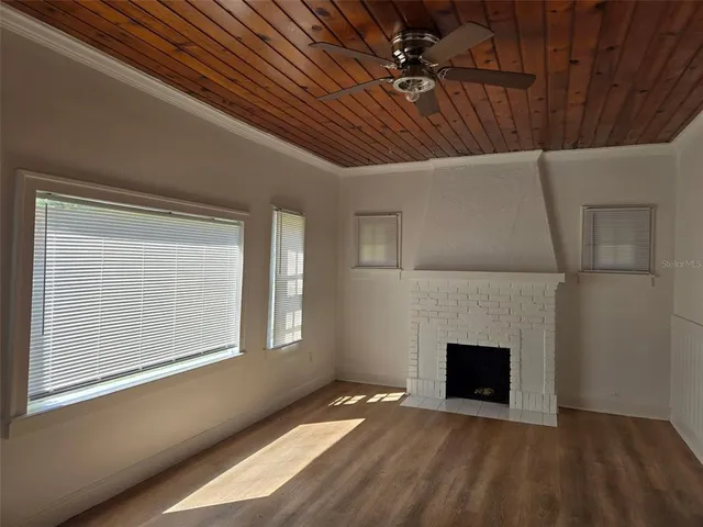 a view of an empty room with a fireplace and a window