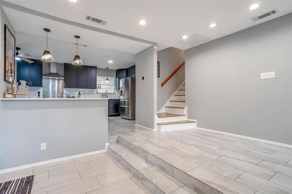 6609 Genoa Road Fort Worth, TX 76116 - Photo 21 of 39 Kitchen with stainless steel fridge, wall chimney range hood, light countertops, recessed lighting, and tasteful backsplash