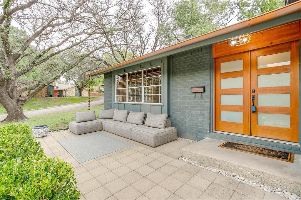 6609 Genoa Road Fort Worth, TX 76116 - Photo 4 of 39 Doorway to property with brick siding, a patio area, a lawn, and board and batten siding