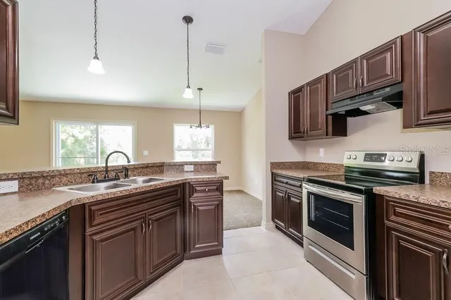 a kitchen with stainless steel appliances granite countertop a sink stove oven and granite counter tops
