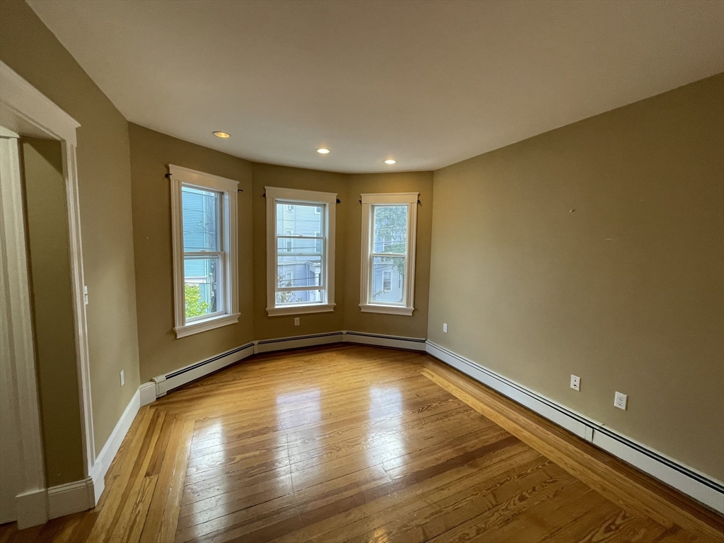 39 Calvin Street, Unit 2 Somerville, MA 02143 - Photo 2 of 11 a view of empty room with wooden floor and fan
