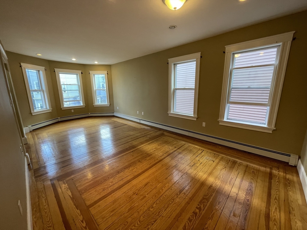 39 Calvin Street, Unit 2 Somerville, MA 02143 - Photo 3 of 11 a view of an empty room with wooden floor and a window