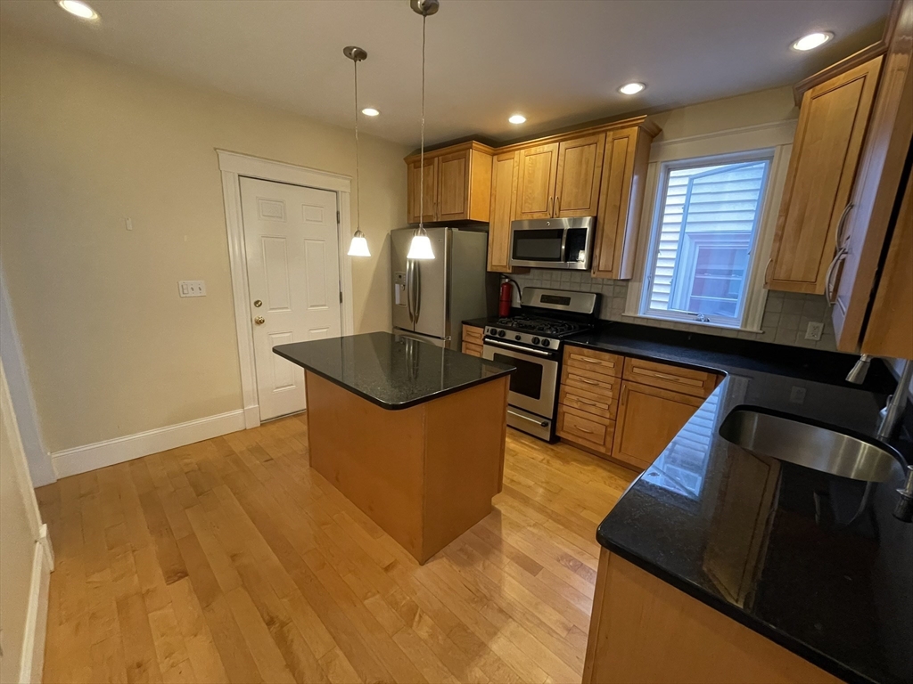 39 Calvin Street, Unit 2 Somerville, MA 02143 - Photo 5 of 11 a kitchen with stainless steel appliances granite countertop a sink stove and refrigerator