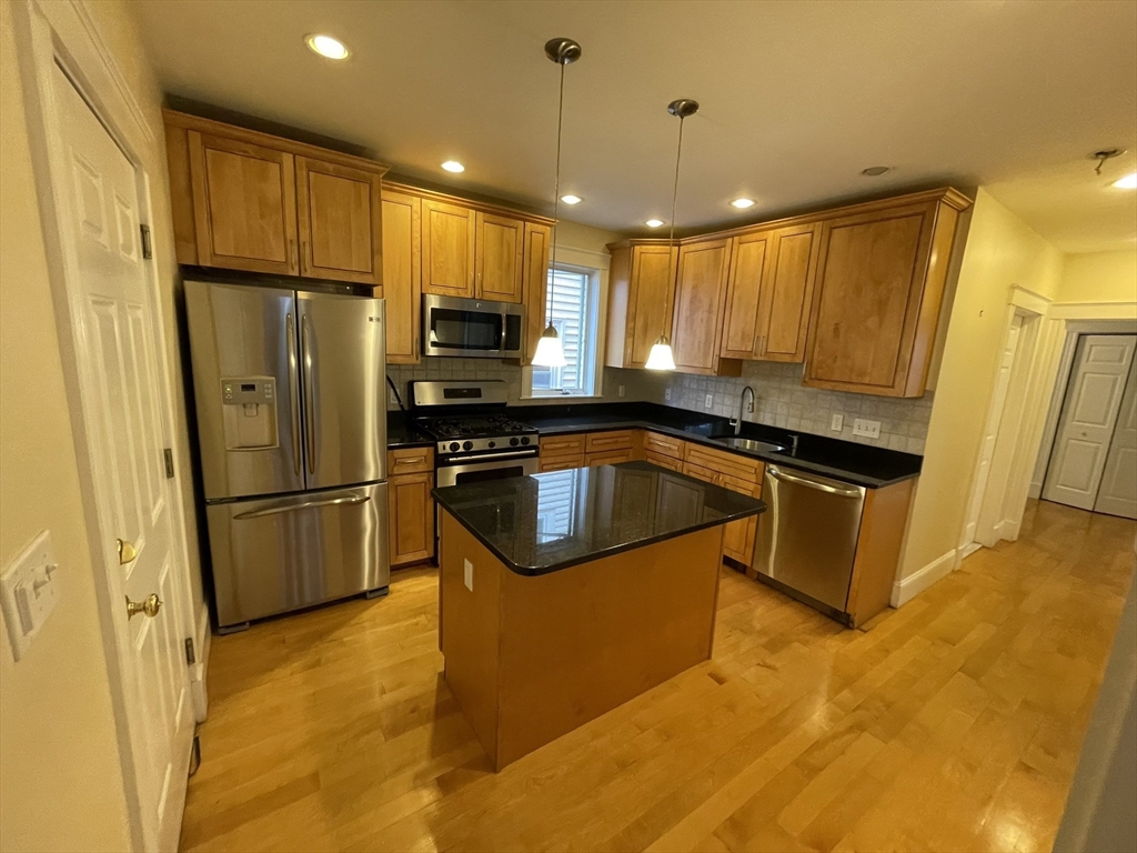 39 Calvin Street, Unit 2 Somerville, MA 02143 - Photo 6 of 11 a kitchen with stainless steel appliances a refrigerator a sink a stove a microwave and island