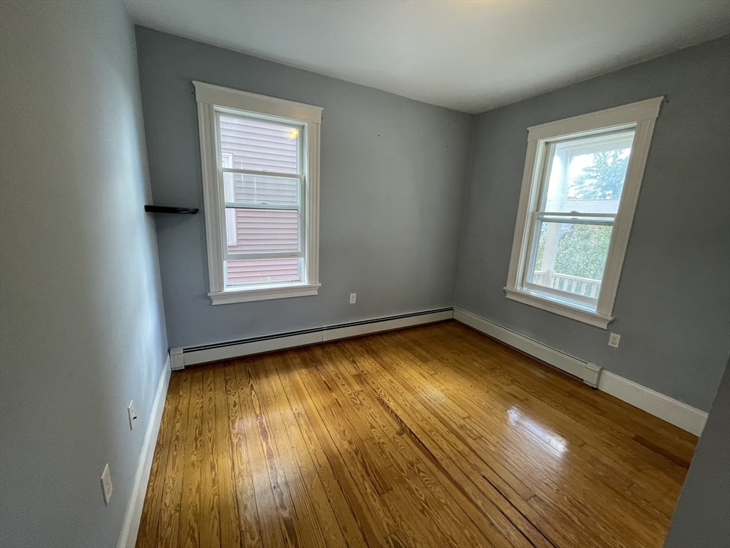 39 Calvin Street, Unit 2 Somerville, MA 02143 - Photo 7 of 11 a view of an empty room with wooden floor and a window