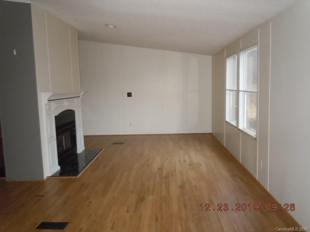 135 Austin Road Clyde, NC 28721 - Photo 4 of 9 an empty room with wooden floor and windows