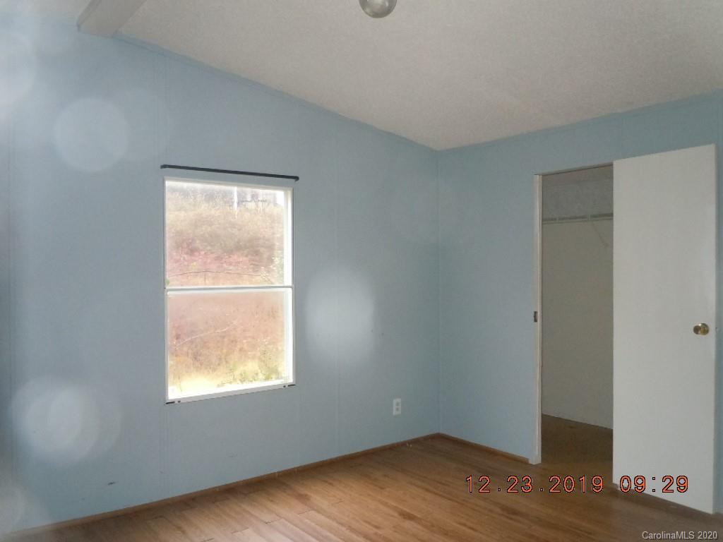 135 Austin Road Clyde, NC 28721 - Photo 5 of 9 an empty room with wooden floor and windows