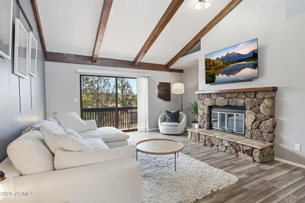a living room with furniture a fireplace and a floor to ceiling window