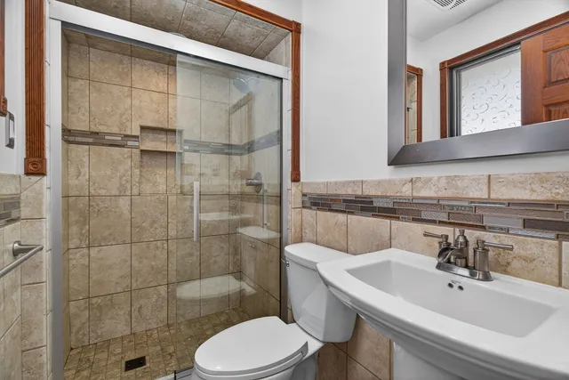 a bathroom with a sink toilet and shower