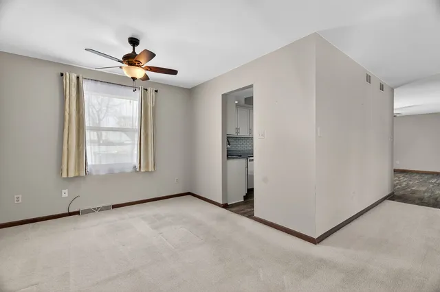 a view of a livingroom with a ceiling fan and window
