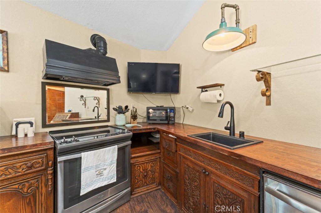 16720 Mil Potrero Frontage Road Pine Mountain Club, CA 93222 - Photo 11 of 39 a kitchen with stainless steel appliances a stove a sink and a microwave