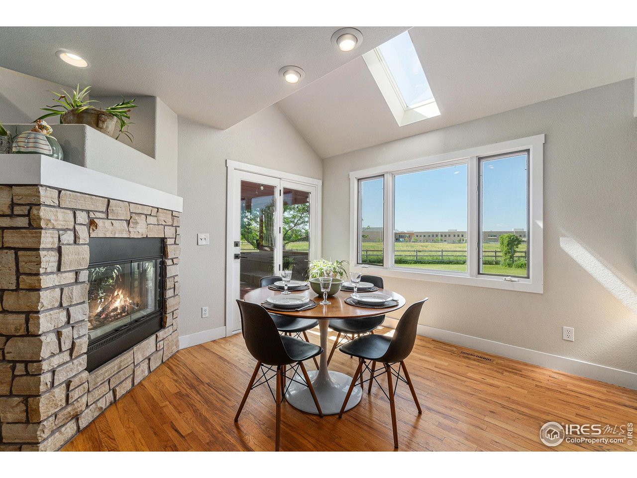 4615 Kitchell Way Fort Collins, CO 80524 - Photo 11 of 41 a dining room with furniture a fireplace and wooden floor