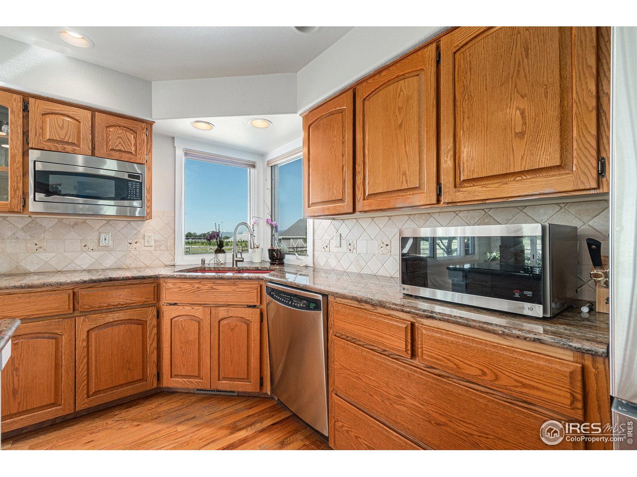 4615 Kitchell Way Fort Collins, CO 80524 - Photo 13 of 41 a kitchen with stainless steel appliances granite countertop a sink stove and microwave