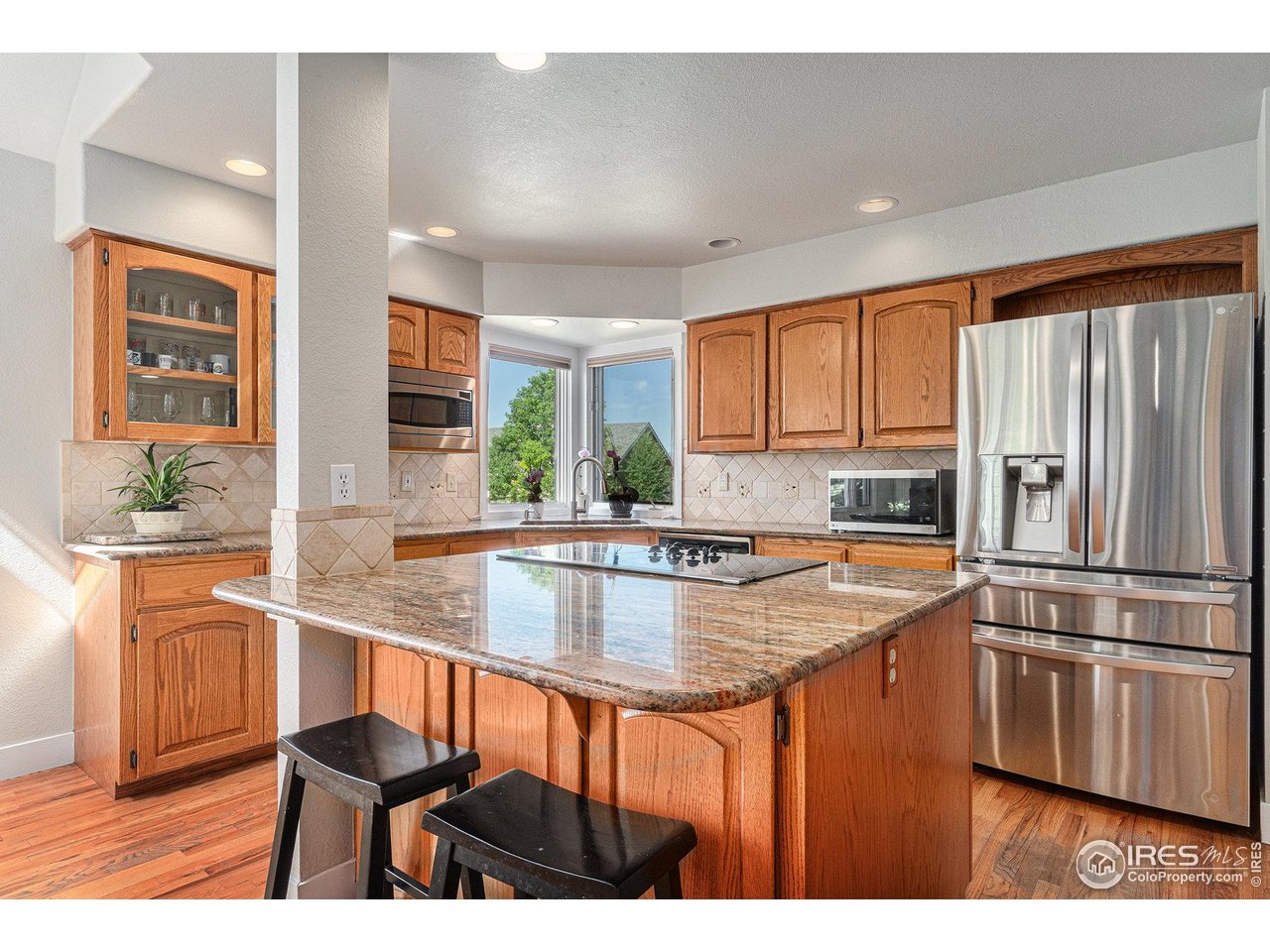 4615 Kitchell Way Fort Collins, CO 80524 - Photo 8 of 41 a kitchen with stainless steel appliances granite countertop a refrigerator a sink a stove a dining table and chairs