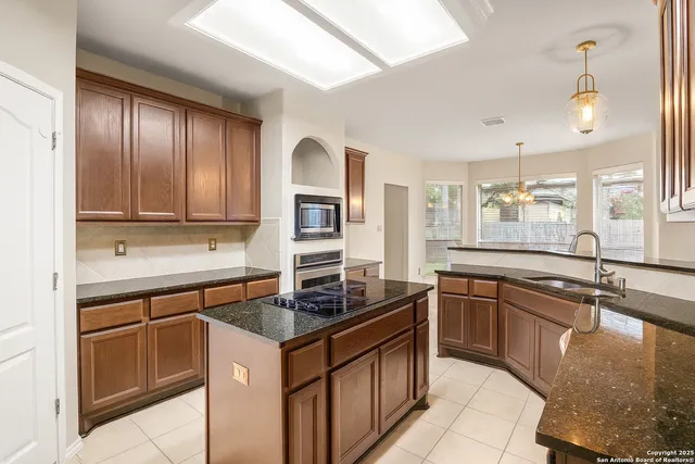 a kitchen with stainless steel appliances granite countertop a sink stove and cabinets