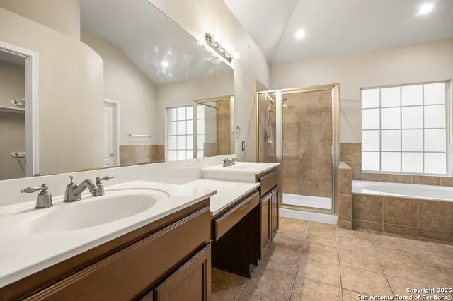 a spacious bathroom with a double vanity sink a mirror and a bathtub