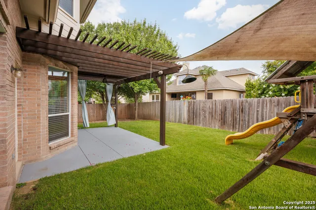 a view of a house with a yard and a large tree