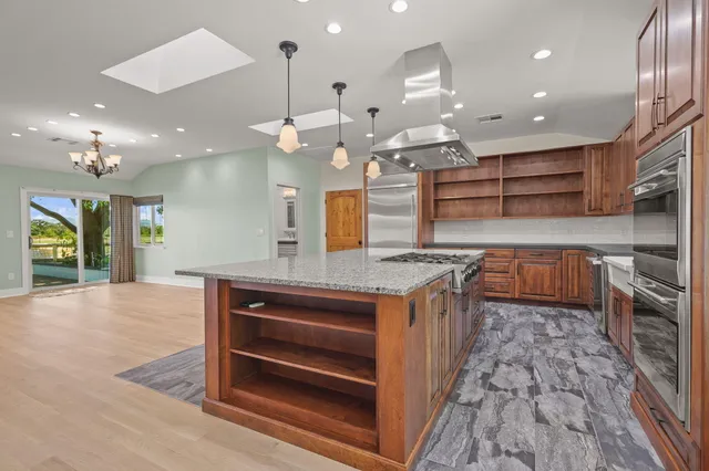 an open kitchen with a sink and breakfast area