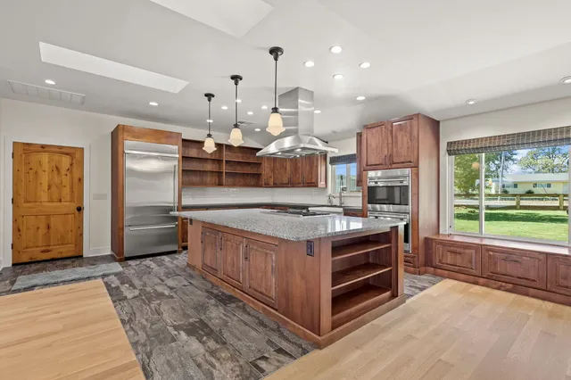 a kitchen with stainless steel appliances granite countertop a stove a sink and a refrigerator