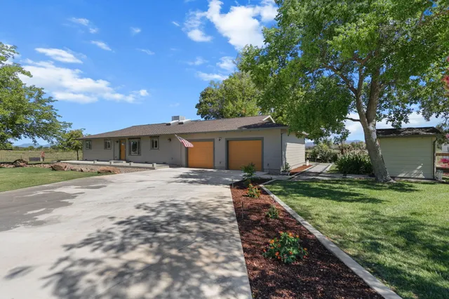 a front view of house with yard and trees around