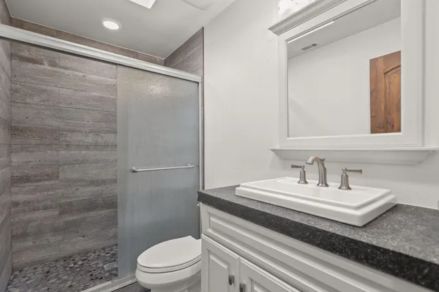 a bathroom with a sink a toilet and shower