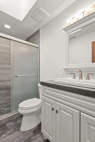 a bathroom with a sink a toilet and shower