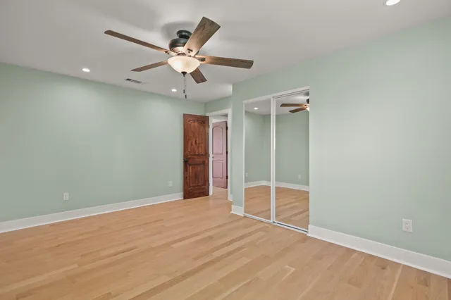 an empty room with closet and fan