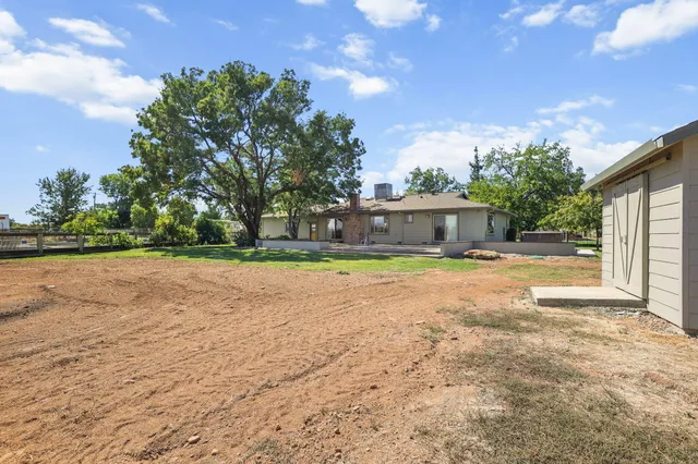 a house view with swimming pool and trees in the background