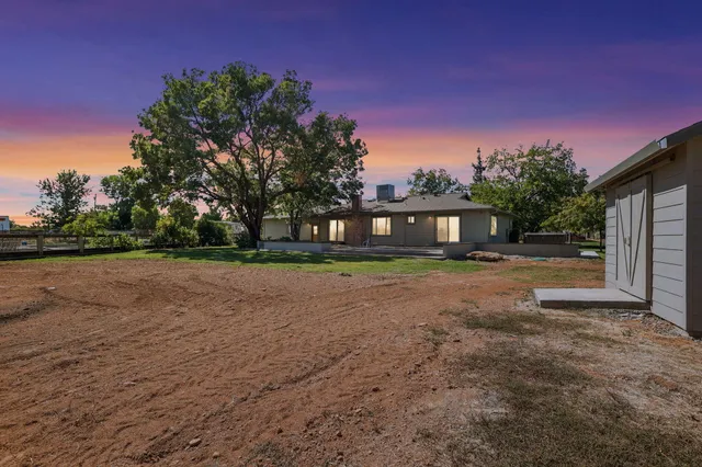 a front view of a house with a yard and trees
