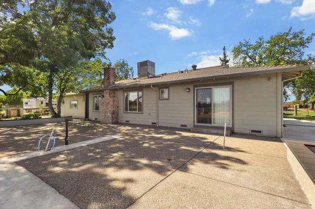 a view of a house with a patio and a yard
