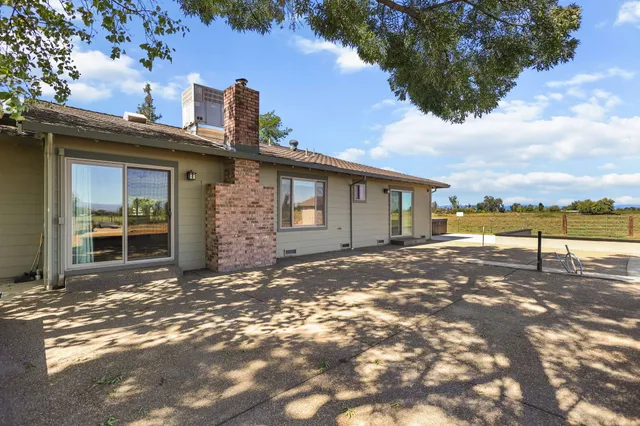 a view of a house with backyard and trees