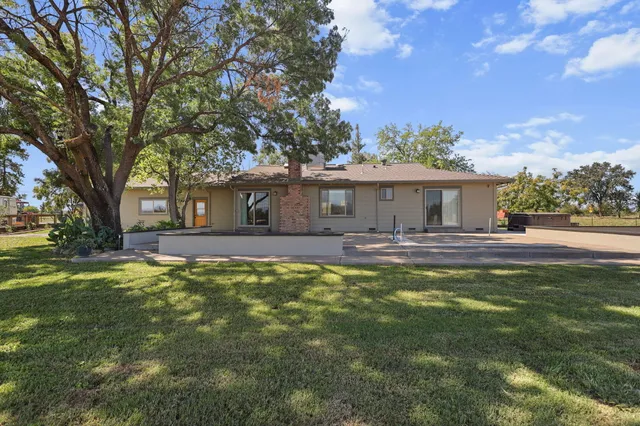 a front view of a house with a yard garage and outdoor seating